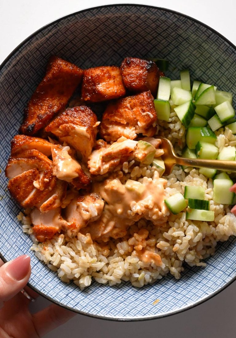 Air fryer salmon in a bowl with rice and cucumber.