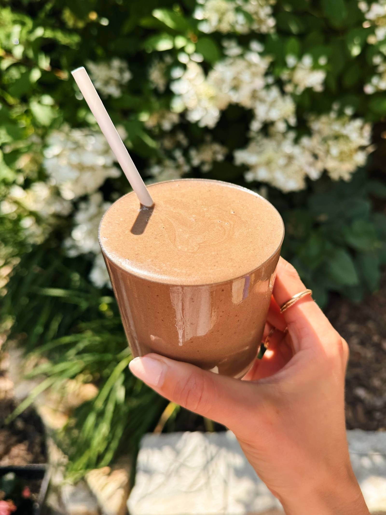 Chocolate cherry smoothie in a glass with a straw.