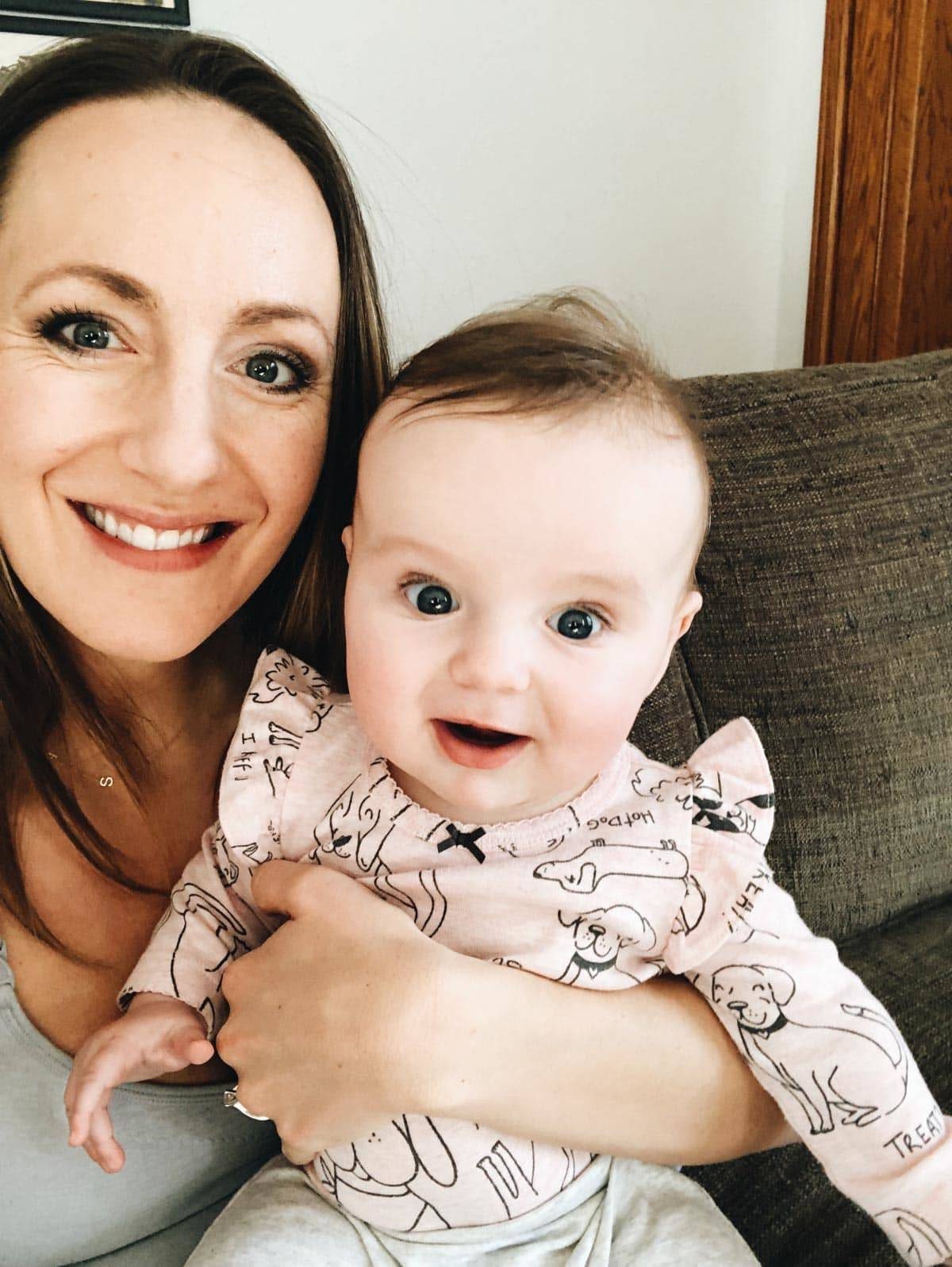 A woman and a baby sitting together.
