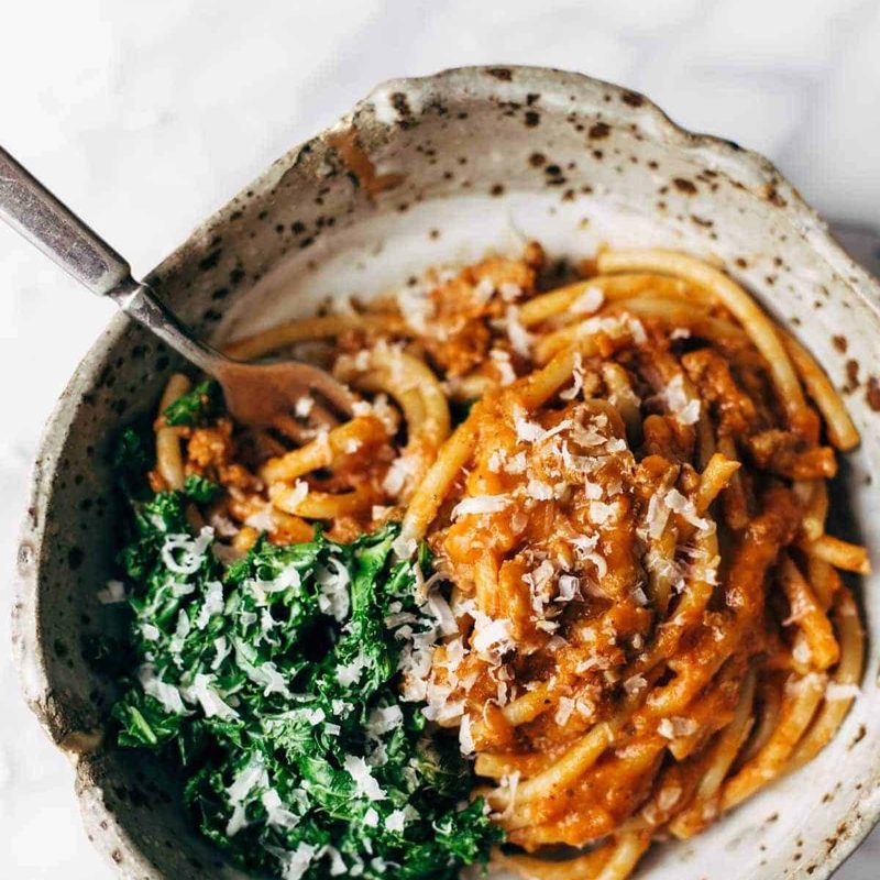 A fork in a dish of pumpkin spaghetti.